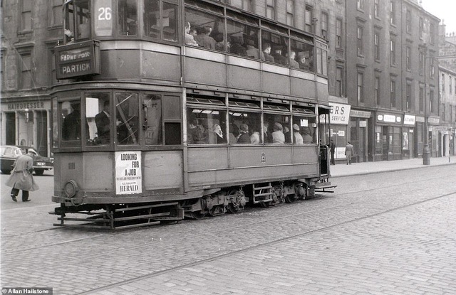 A tram packed full of passengers makes its way up Arygle Street in central Glasgow in April 1960. It is a number 26 service heading towards Farme Cross in the Rutherglen area of the city as well as Partick on the north bank of the River Clyde 